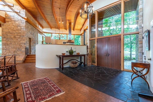 entrance foyer with wooden ceiling, beam ceiling, a high ceiling, and a notable chandelier