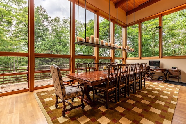 sunroom / solarium with wooden ceiling, a wealth of natural light, and vaulted ceiling with beams