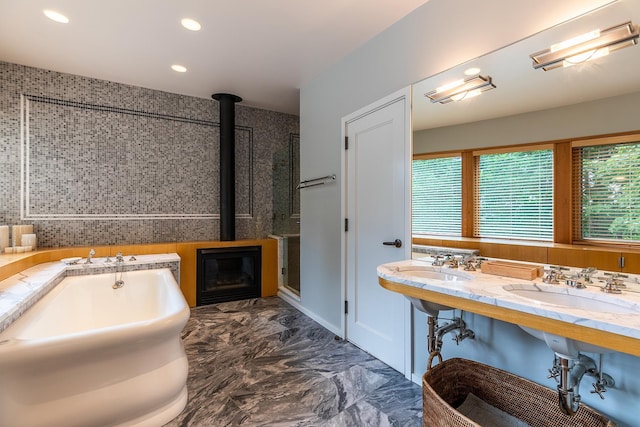 bathroom featuring double sink and a bath