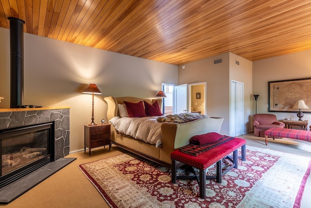 bedroom with a closet, light carpet, wood ceiling, and a fireplace