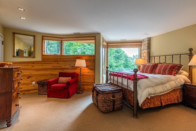 carpeted bedroom featuring wooden walls