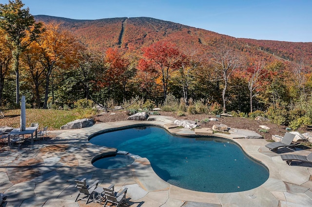 view of pool featuring a mountain view, an in ground hot tub, and a patio