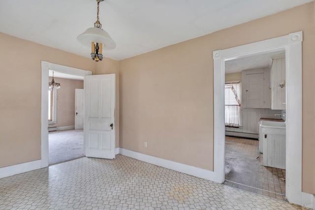 unfurnished room with a baseboard radiator and a notable chandelier