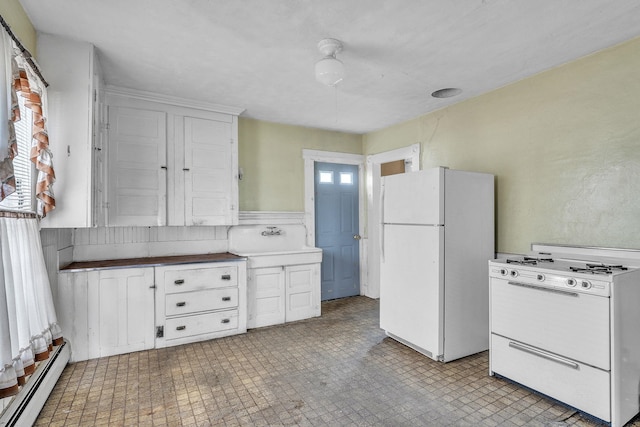 kitchen featuring sink, white appliances, a baseboard radiator, and plenty of natural light