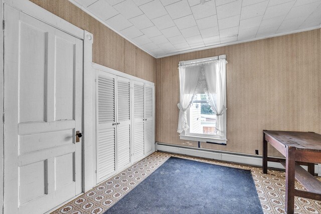 interior space with crown molding, a baseboard radiator, and a closet