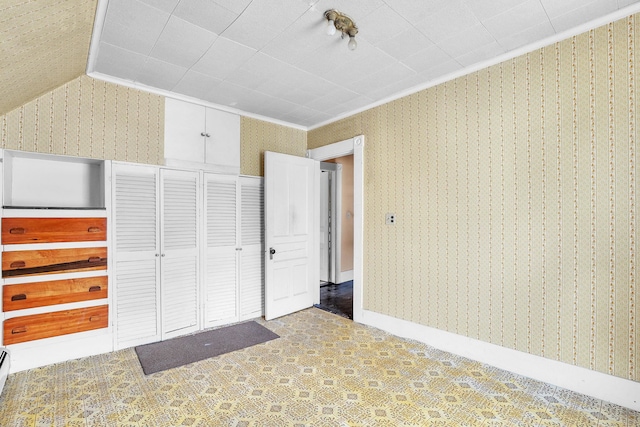 unfurnished bedroom with ornamental molding and lofted ceiling