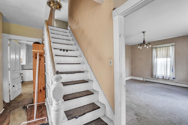 stairway with a baseboard heating unit, carpet flooring, and a notable chandelier