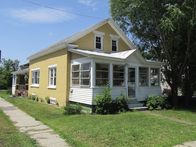 view of front facade featuring a front yard and a sunroom