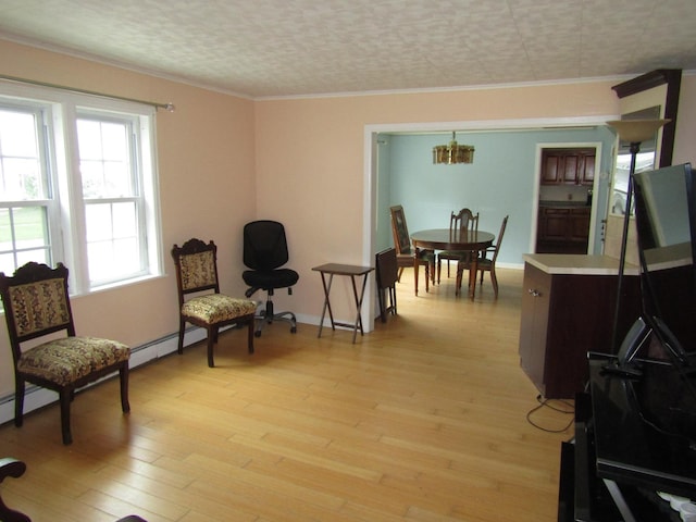 living area featuring ornamental molding, light hardwood / wood-style flooring, a notable chandelier, and a textured ceiling