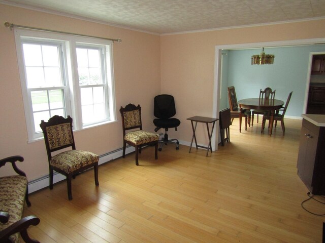 living area with baseboard heating, light hardwood / wood-style flooring, a textured ceiling, a notable chandelier, and ornamental molding