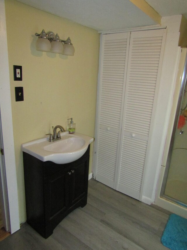 bathroom with vanity, walk in shower, and hardwood / wood-style floors