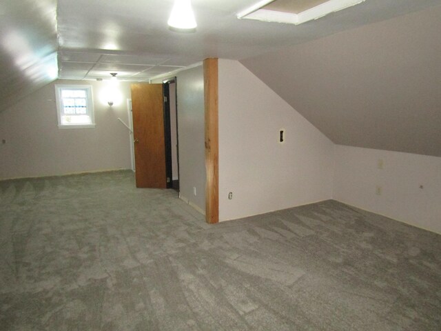 bonus room featuring vaulted ceiling and carpet