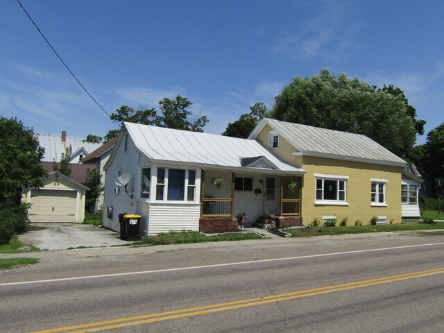 view of front of home with a garage, an outdoor structure, and a porch