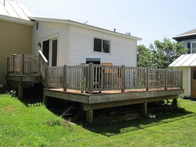 back of house with a wooden deck and a lawn