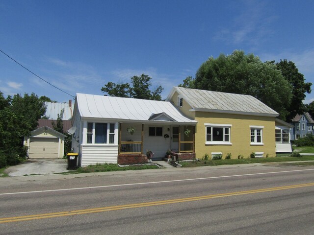 single story home with an outdoor structure, a porch, and a garage