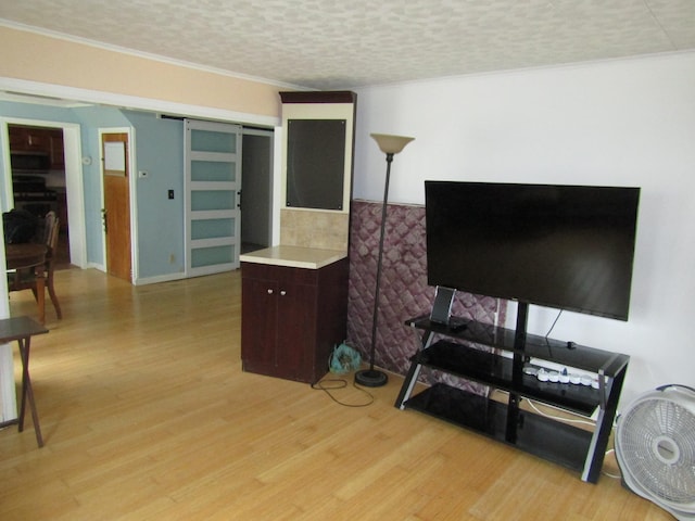 home office featuring light hardwood / wood-style floors, a textured ceiling, and ornamental molding