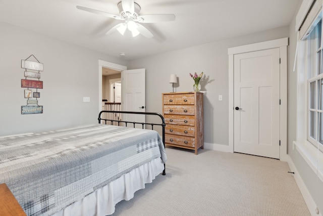 bedroom with light carpet, ceiling fan, and baseboards