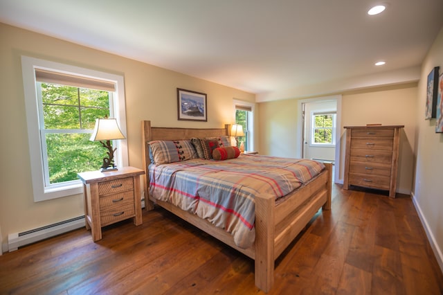 bedroom with dark hardwood / wood-style floors and baseboard heating