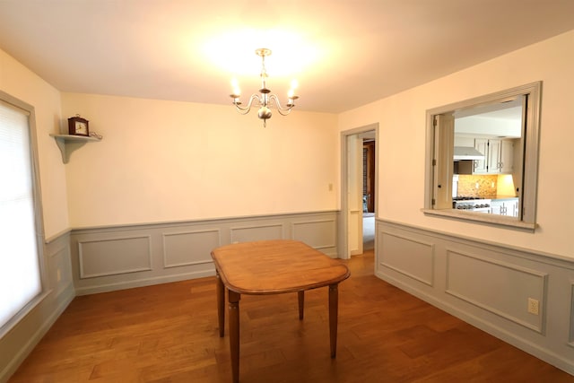 unfurnished dining area with a chandelier and light wood-type flooring