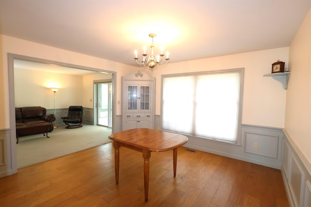 dining area with light colored carpet and a chandelier