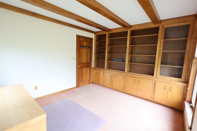 carpeted empty room with beam ceiling