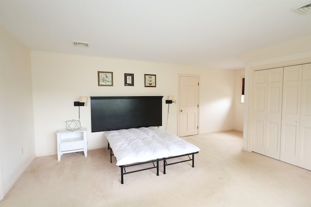 bedroom featuring light carpet and a closet