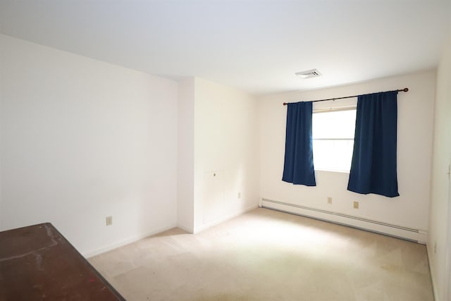 carpeted spare room featuring baseboard heating