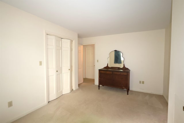 bedroom featuring a closet and light colored carpet