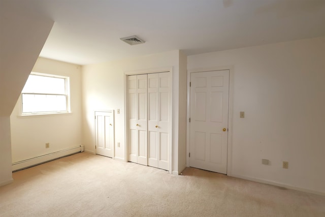 unfurnished bedroom with a baseboard radiator and light carpet