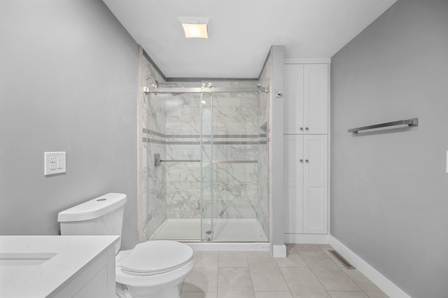 bathroom with vanity, a shower with door, and toilet