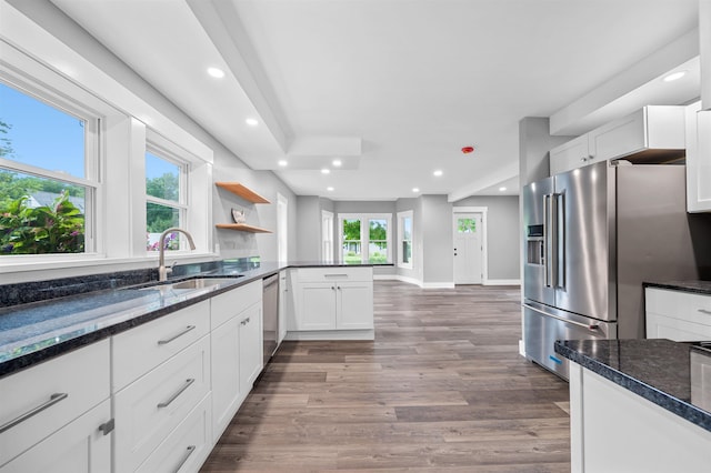 kitchen featuring appliances with stainless steel finishes, white cabinets, and dark stone counters