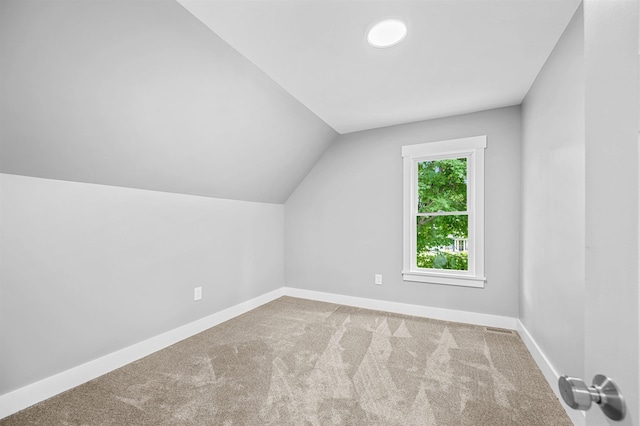 bonus room with carpet flooring and vaulted ceiling