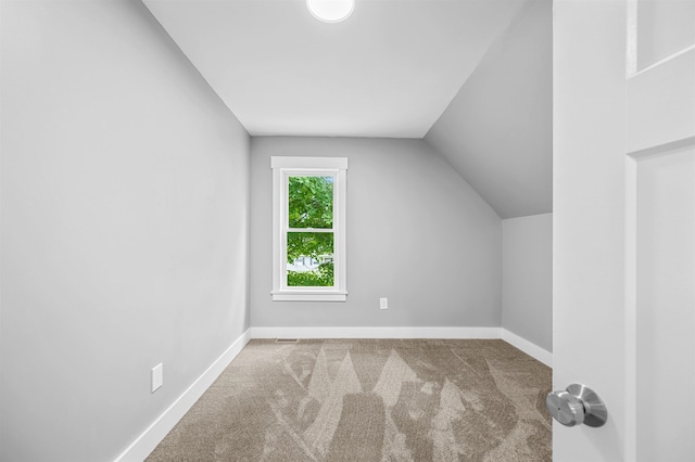 bonus room with vaulted ceiling and carpet