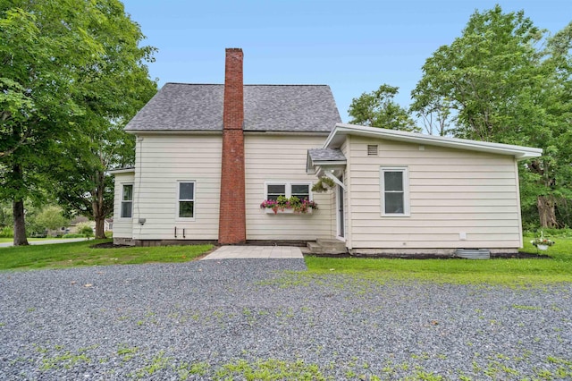 back of house featuring a lawn