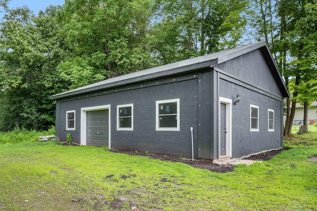 exterior space featuring a garage and a lawn