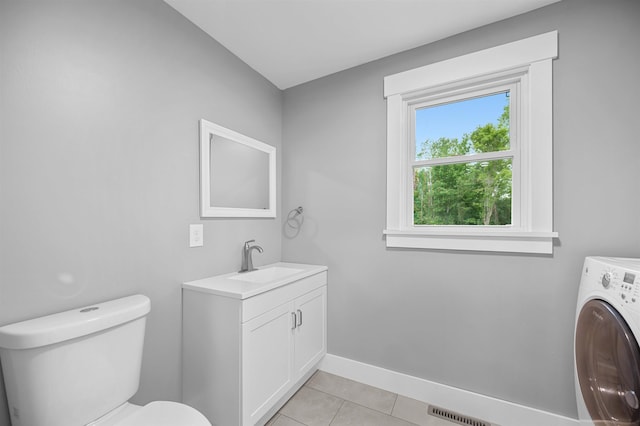 bathroom featuring vanity, washer / clothes dryer, tile patterned flooring, and toilet