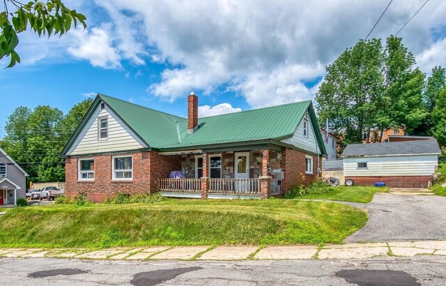 view of front of property with covered porch and a front yard