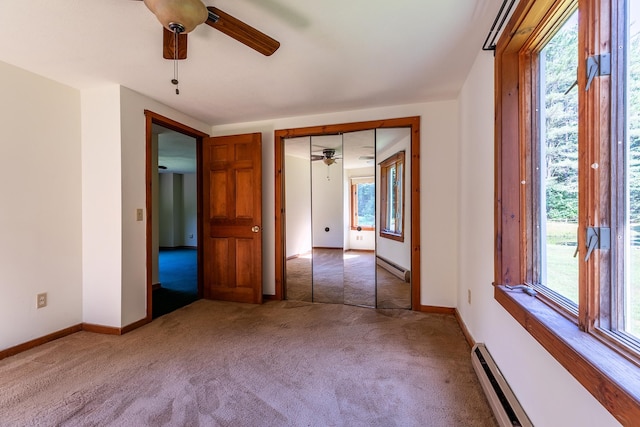 unfurnished room featuring ceiling fan, carpet floors, baseboard heating, and plenty of natural light