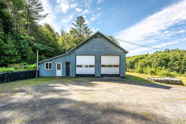 exterior space with a garage and a lawn