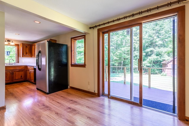 kitchen featuring sink, stainless steel fridge, and light hardwood / wood-style floors