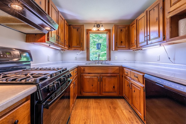 kitchen featuring light wood-type flooring, sink, and black appliances