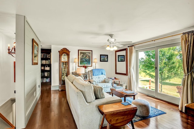 living room featuring dark hardwood / wood-style floors and ceiling fan with notable chandelier