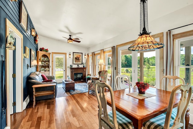 dining space featuring vaulted ceiling, wood-type flooring, and ceiling fan