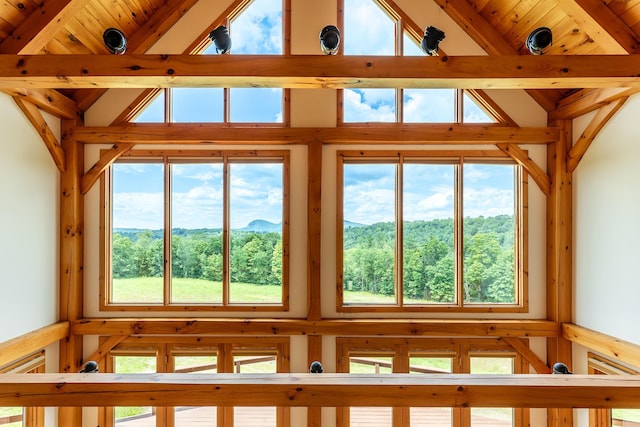 unfurnished sunroom with plenty of natural light, vaulted ceiling with beams, and wood ceiling