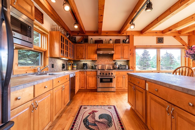 kitchen with sink, stainless steel appliances, light hardwood / wood-style floors, and extractor fan