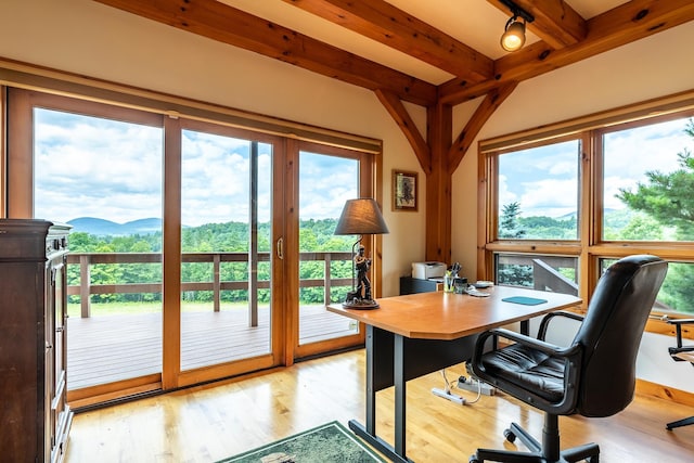 home office featuring beam ceiling, a mountain view, and light hardwood / wood-style flooring