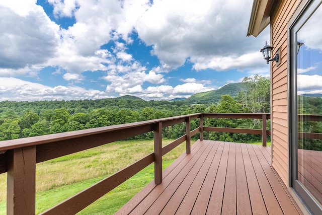 wooden terrace featuring a mountain view and a yard