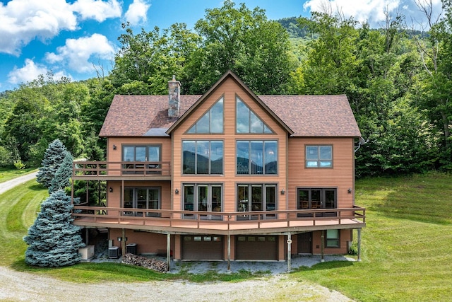 back of property featuring a wooden deck, central AC unit, and a lawn