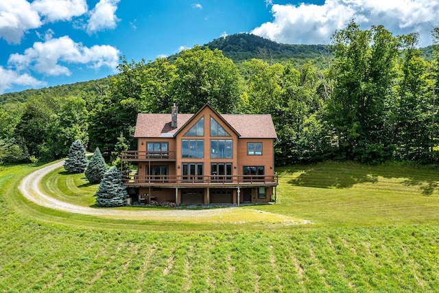 back of house featuring a wooden deck and a yard