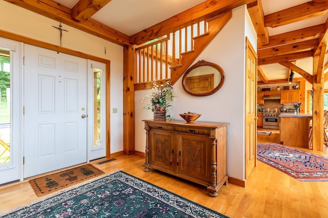 entrance foyer featuring beamed ceiling and light hardwood / wood-style floors